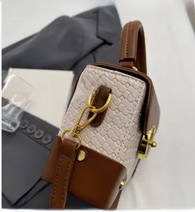 Detailed side view of beige woven box bag featuring premium brown leather and gold hardware