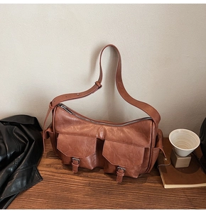 Detail of vintage brown PU leather shoulder bag with buckle pockets and retro texture