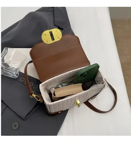 Spacious interior of a brown leather and beige woven crossbody bag showing ample storage