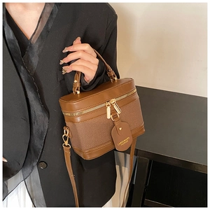 Detail of vintage brown bucket bag showing synthetic leather texture and gold hardware