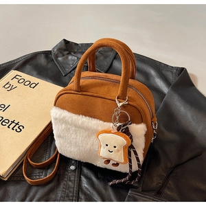 Close-up of a brown suede mini bag with white plush trim and a cute toast charm