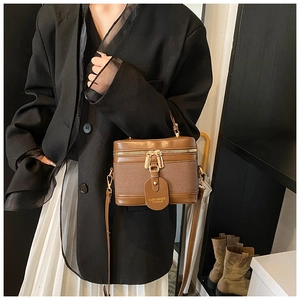 Detail of a vintage brown crossbody box bag with woven texture on a fashion model