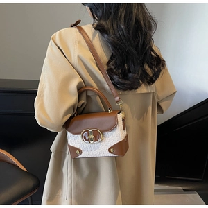 Rear view of a model wearing the brown leather and beige woven patchwork handbag with strap