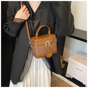 Detail of vintage brown bucket bag with gold zippers and stylish crossbody strap