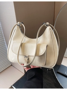 Minimalist cream-colored crescent underarm bag with functional front flap and buckle detail