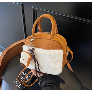Detail of mini plush handbag with faux fur trim and cute toast charm on a vintage chair