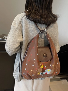 Brown leather backpack with colorful polka dots and cute dog embroidery in a back view