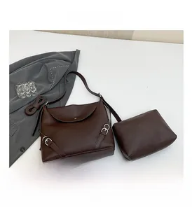 Detailed top view of brown leather hobo bag and small pouch set with silver metal hardware