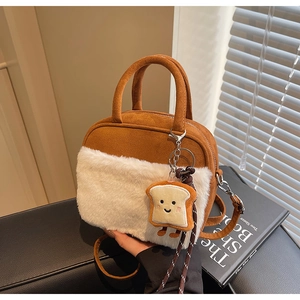 Detail of suede crossbody bag with plush trim and cute toast-shaped charm pendant
