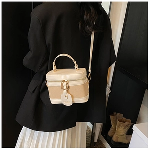 Close-up of color-block bucket bag with metallic zippers and leather brand tag detail