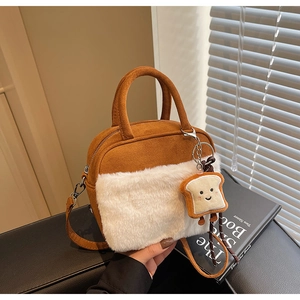 Detailed view of suede tote with plush fur trim and cute toast charm accessory