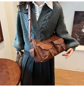 Detail of vintage brown shoulder bag with multiple functional pockets and metal buckles