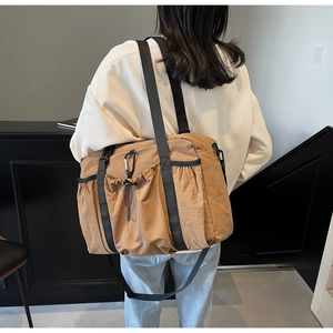 Detail of camel nylon tote bag with drawstring pocket and silver carabiner on back
