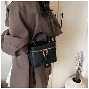 Detail of black vintage bucket bag featuring textured leather and gold-tone zippers