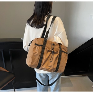 Detail of khaki nylon bucket bag with drawstring pocket and black carabiner clip