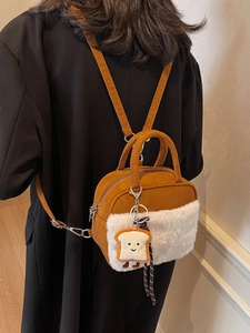 Brown suede and white plush mini crossbody bag with cute cartoon toast pendant on a model