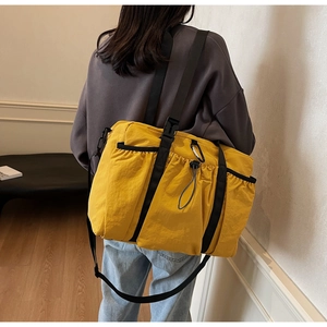 Detailed back view of model wearing a ginger yellow bucket bag with adjustable strap