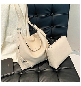 Close-up of off-white lychee grain leather tote bag with matching zipper pouch
