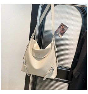 Detail of cream white pebbled leather hobo bag showing silver buckle and magnetic closure