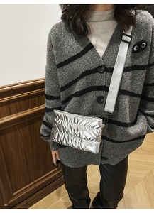 Detail of silver quilted crossbody bag with adjustable wide strap on a model