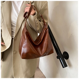 Detail of vintage brown leather hobo bag showing oily finish and fashion embossed label