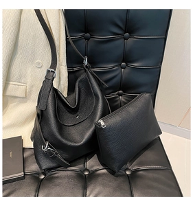 Close-up of black lychee grain leather tote bag set with silver hardware and soft texture
