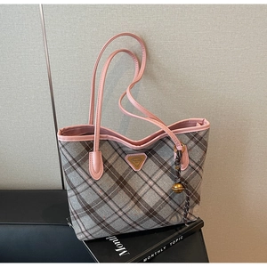 Detailaufnahme der grauen Karo-Tasche mit rosa Lederbesatz und Logo-Plakette