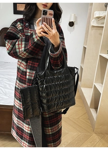 Detail view of black quilted puffer tote bag with matching mini pouch and dual straps