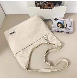 Detailed macro view of nylon shoulder bag with MACHUGE brand label and braided drawstrings