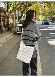 Detailed macro view of white quilted puffer tote bag with glossy nylon finish and wide handles