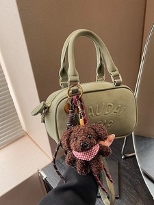 Olive green mini Boston bag with plush dog charm and long shoulder strap