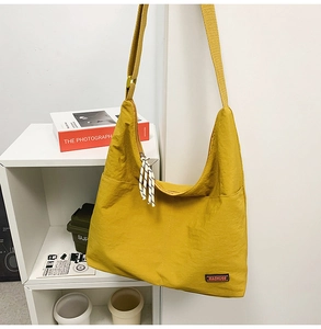 Detail of yellow nylon tote bag featuring brand logo and checkered zipper drawstring