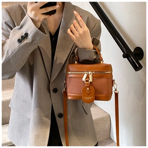 Detail of vintage orange-brown bucket bag with top handle and CAROLMANTI leather tag