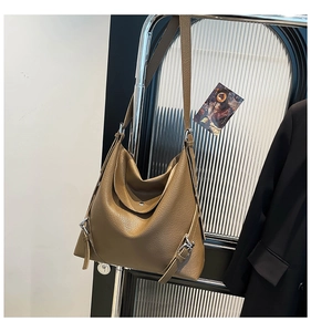 Detailed view of brown lychee-textured leather tote with silver metal buckle accents