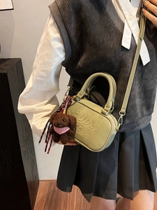 Bean green mini crossbody bag with embossed text and plush teddy bear charm detail