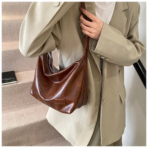Detail of vintage brown leather hobo bag with Fashion & Bag label and soft texture