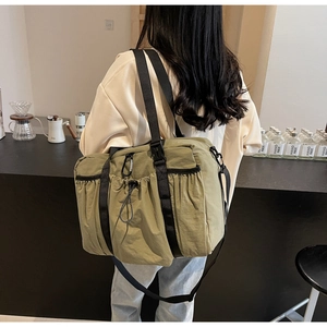 Detail of olive green tactical travel bag with drawstring pocket and nylon straps