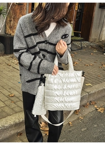 Detail of white quilted tote bag and matching mini pouch with glossy metallic finish