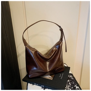 Close-up of vintage brown leather bag detail with embossed logo on art book base