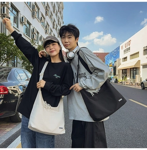 Street style shot of large canvas crossbody bags in black and beige for daily commuting