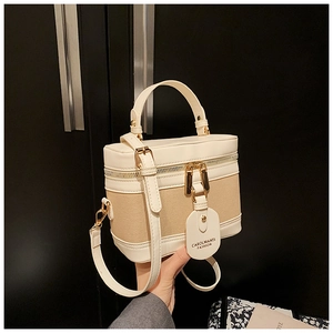 Detail of the canvas and cream leather vanity bag showing stitching and texture