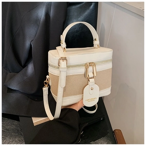 Detail of canvas bucket bag showing leather trim, dual gold zippers and CAROLMANTI tag