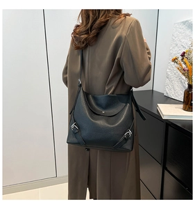 Close-up of black leather tote bag featuring rich pebble texture and silver side buckle
