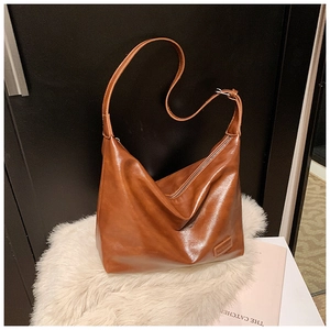 Macro detail of brown retro leather shoulder bag with zipper and brand embossing