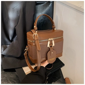 Detail of vintage brown canvas bucket bag with gold zippers and adjustable strap