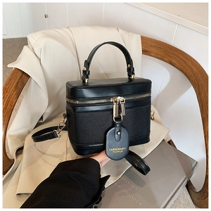 Detail view of black vintage bucket bag with gold zippers and detachable strap