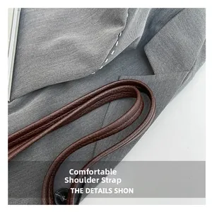 Detailed macro shot of dark brown pebbled leather shoulder strap with neat stitching