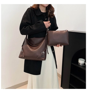 Detailed macro view of dark brown pebbled leather tote set with metallic side buckle accents