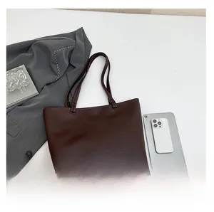 Detailed top view of brown faux leather tote bag with tablet for size reference