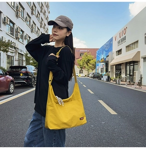 Close-up of bright yellow nylon crossbody bag with adjustable strap and front pocket